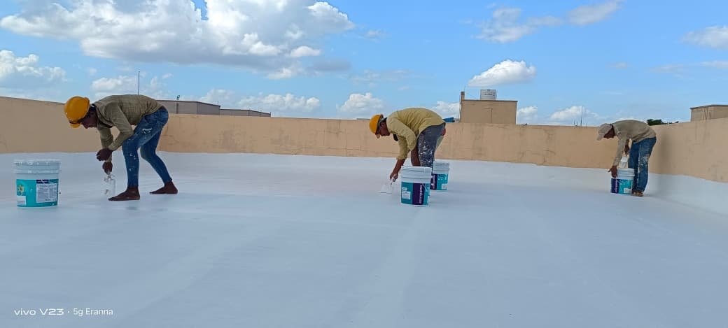 Waterproofing team applying a protective coating across a terrace in Hyderabad